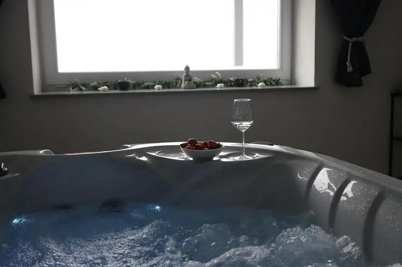 Mjehurići u unutarnjem jacuzziju, čaša vina i jagode